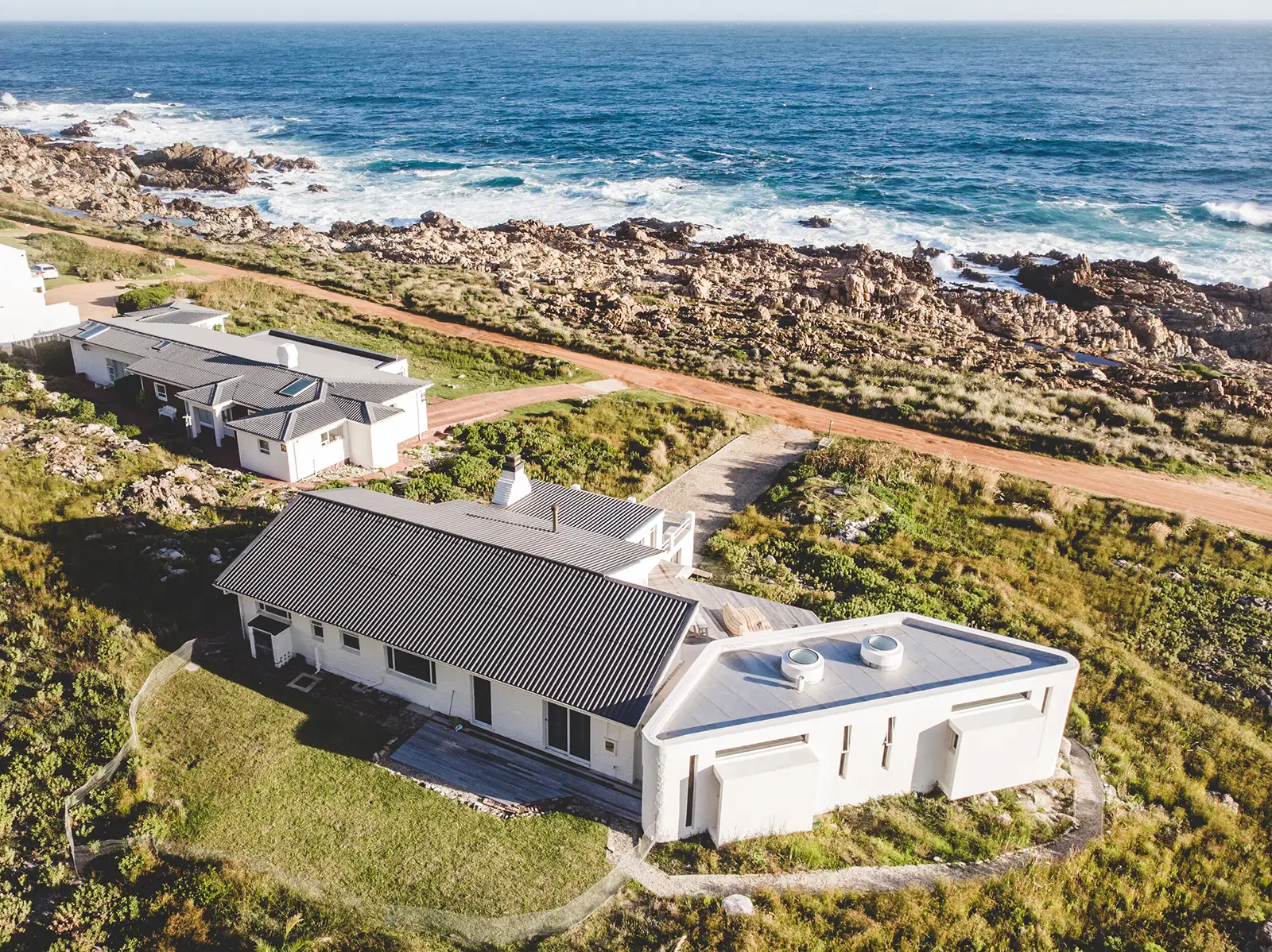Aerial view of the house on the rocky coastline with the Atlantic Ocean beyond