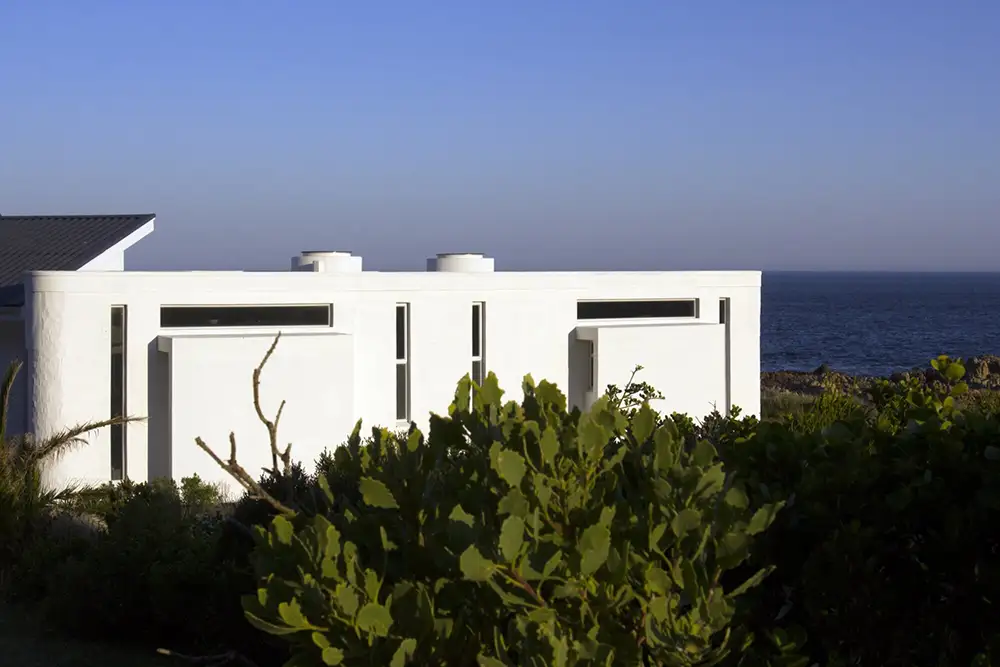 White addition seen over coastal shrubs with the sea behind