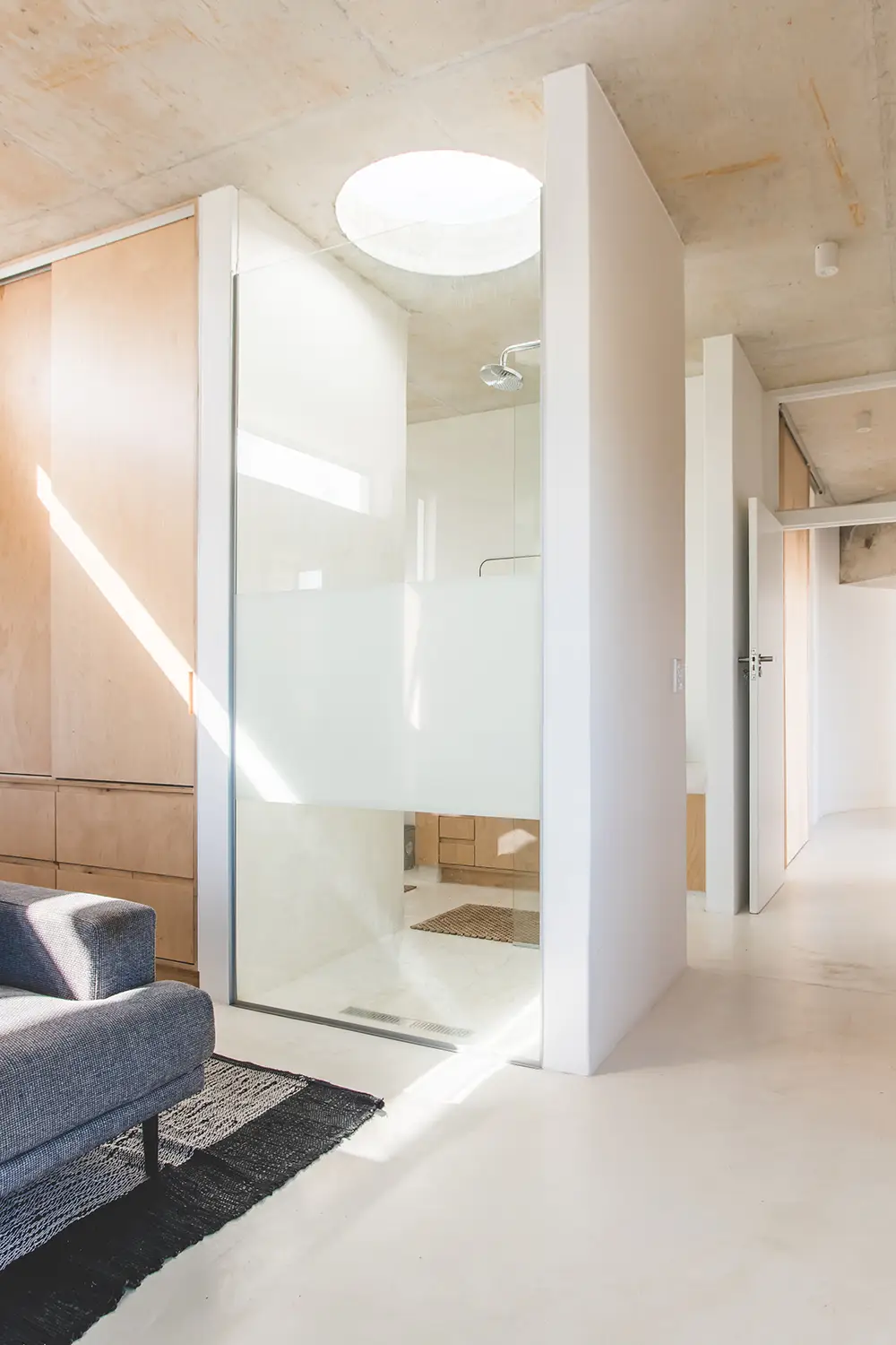 Glass shower beneath a round skylight