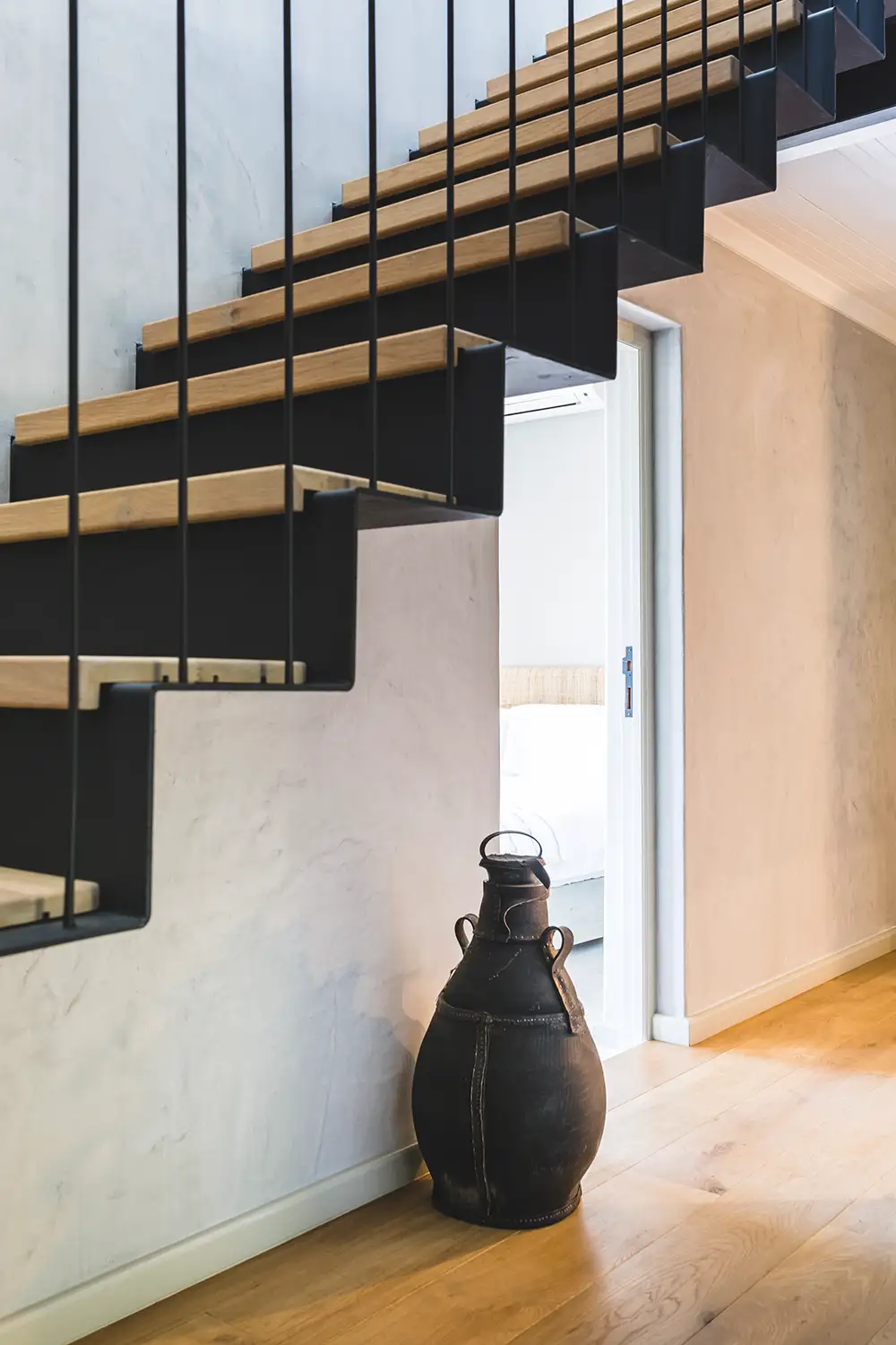 Detail of the floating stair treads and a ceramic vessel