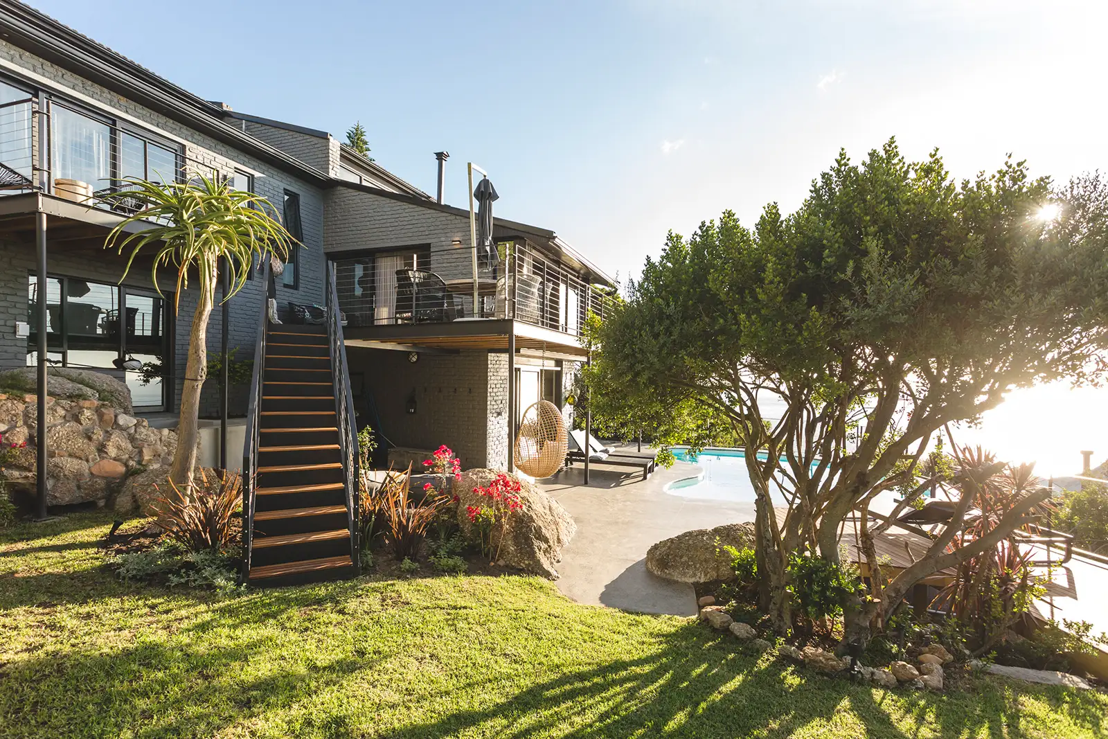 House above a terraced garden with a timber stair and trees