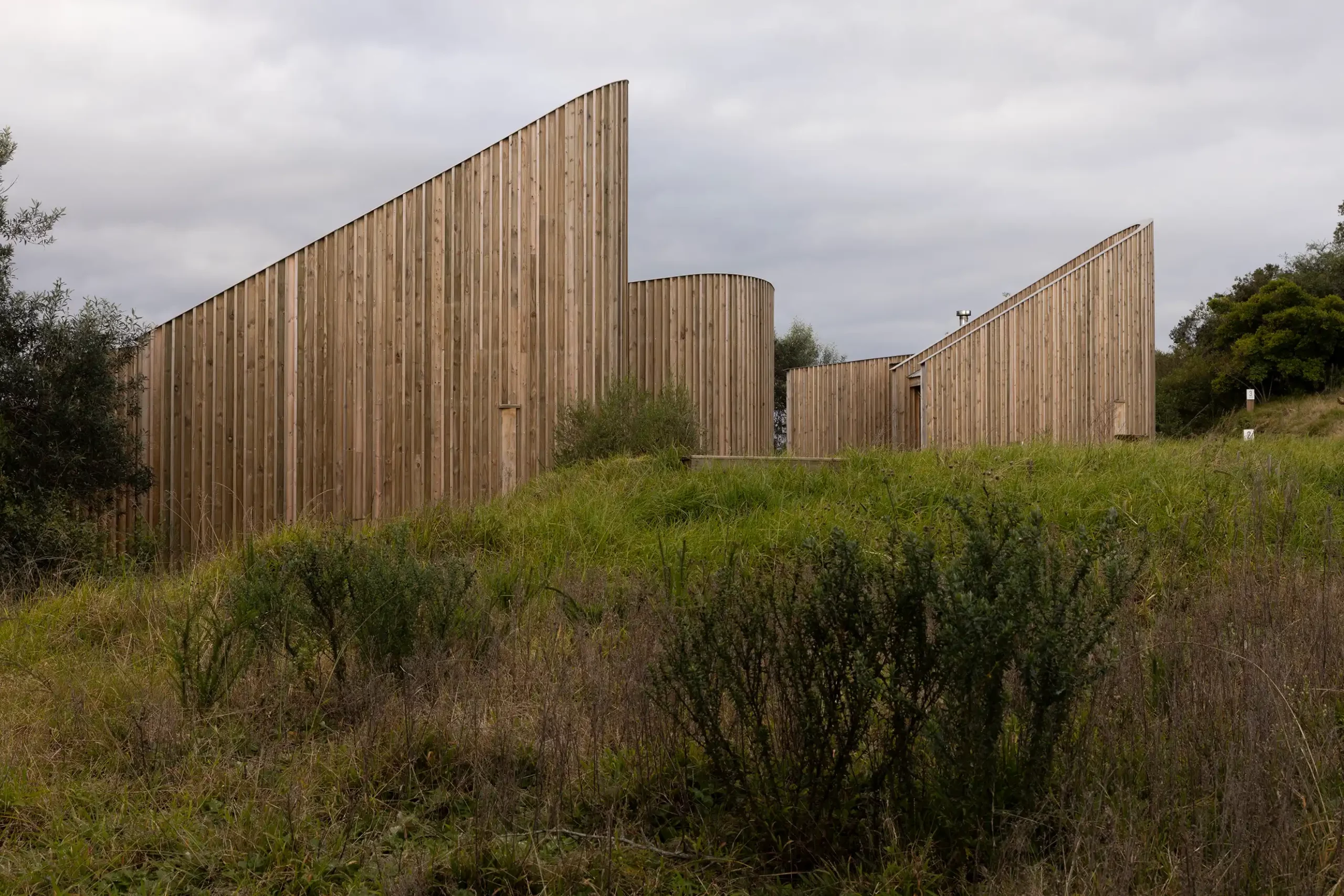 Row of sloping timber walls in the grassland