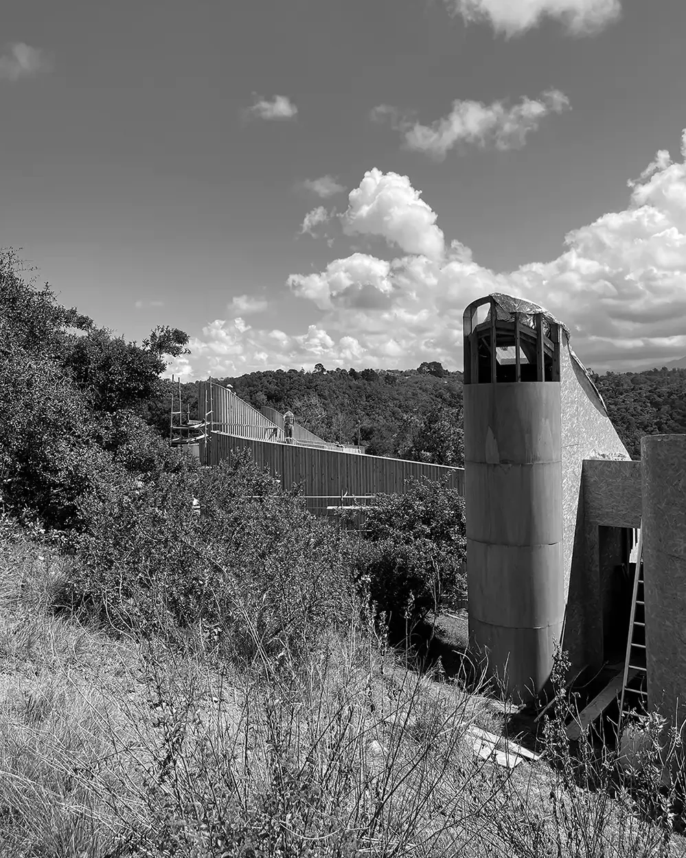 Curved timber tower under construction on the hillside