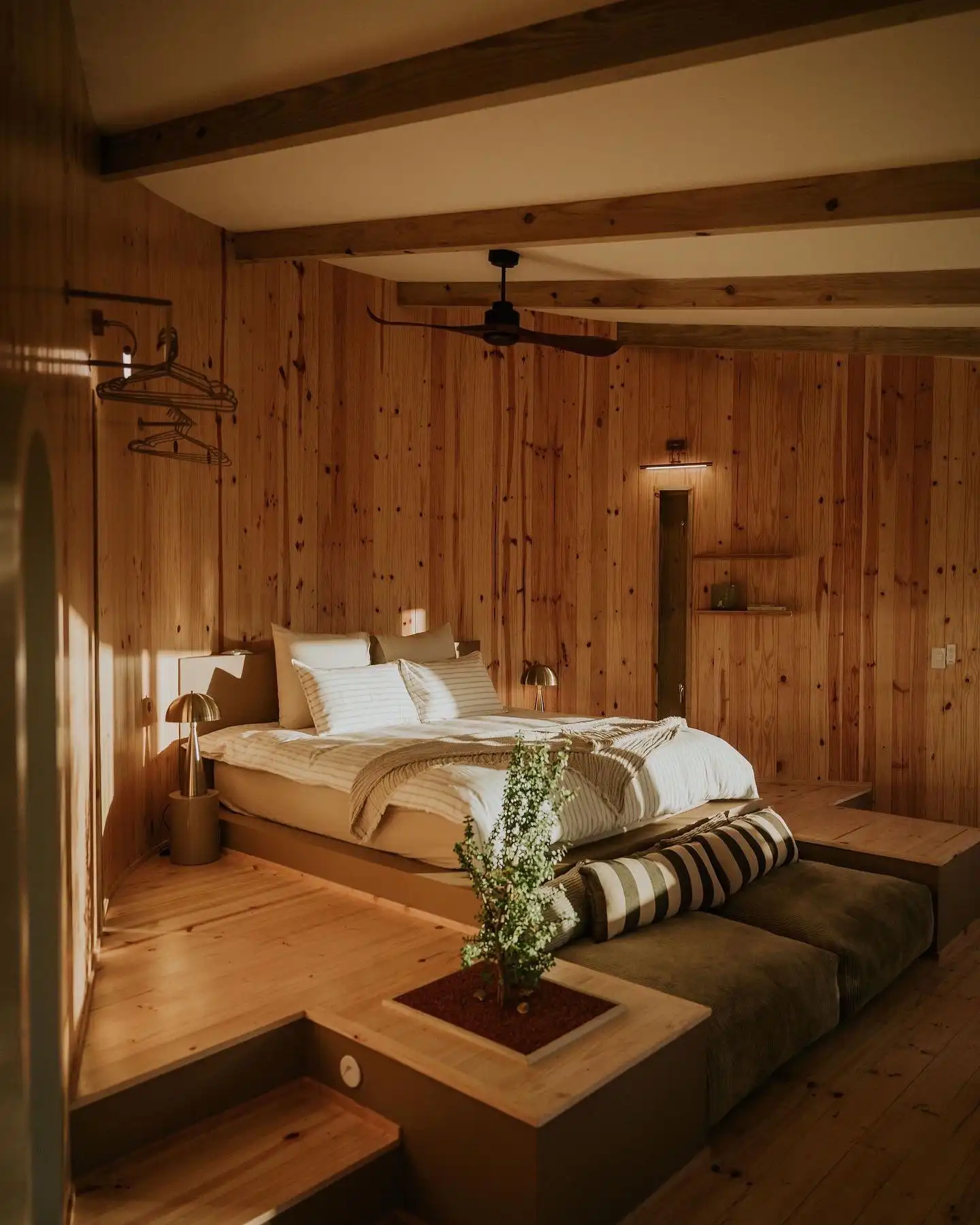 Timber-lined bedroom with a raised bed