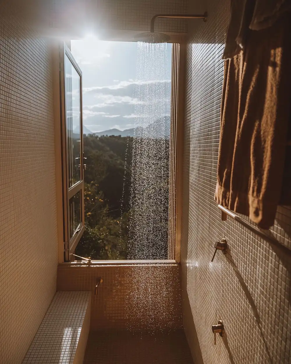 Shower with a full-height window looking onto the forest