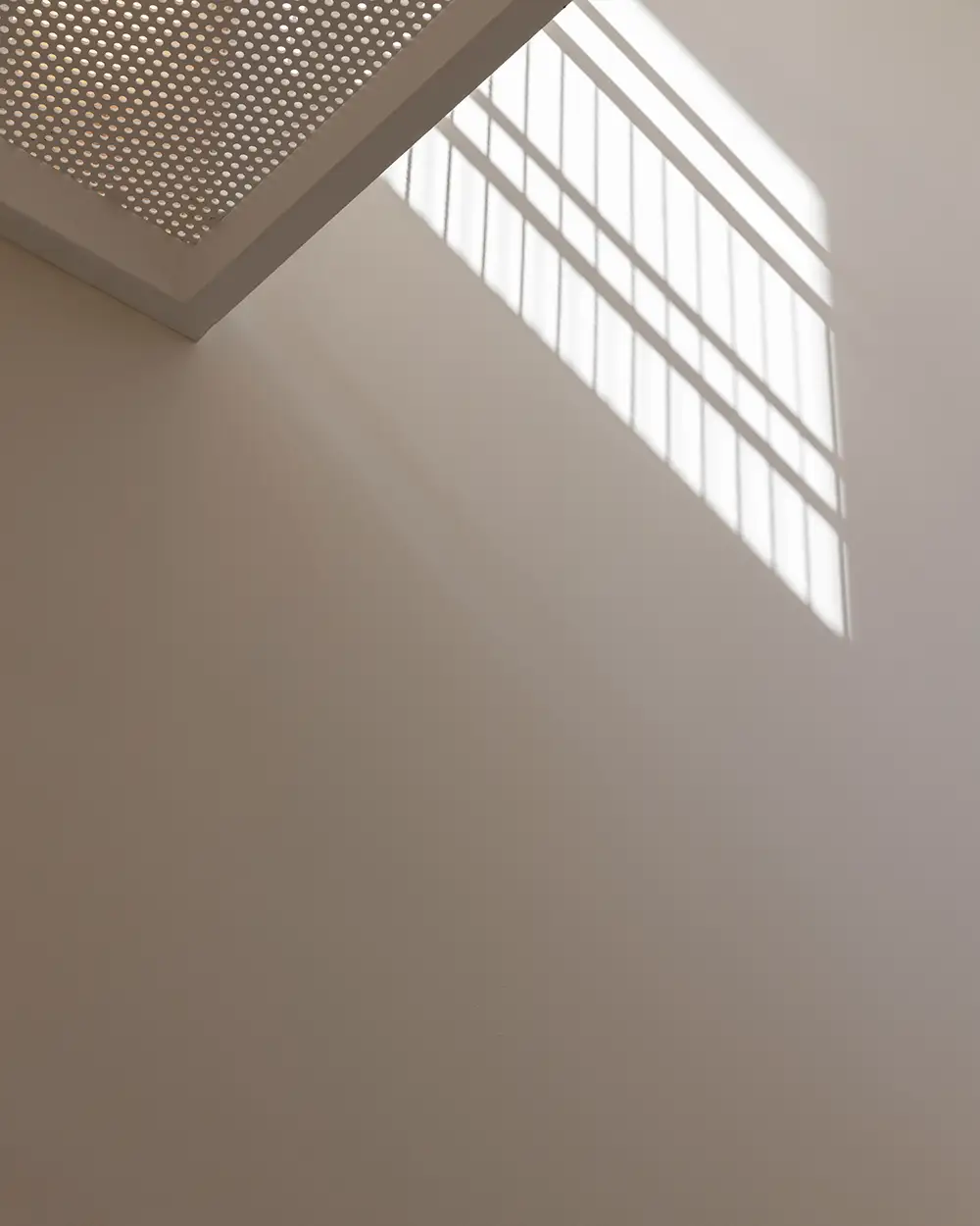 Sunlight through the stair balustrade on a white wall