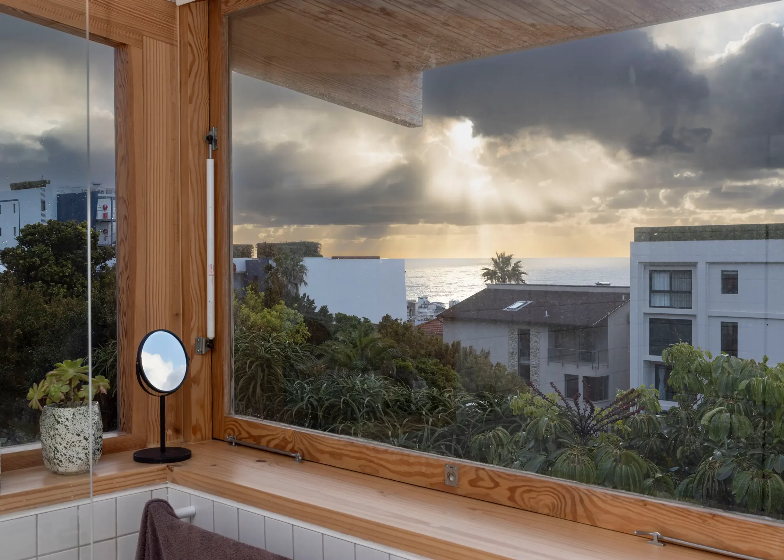 Corner window with a timber frame looking over Ocean View Drive towards the sea