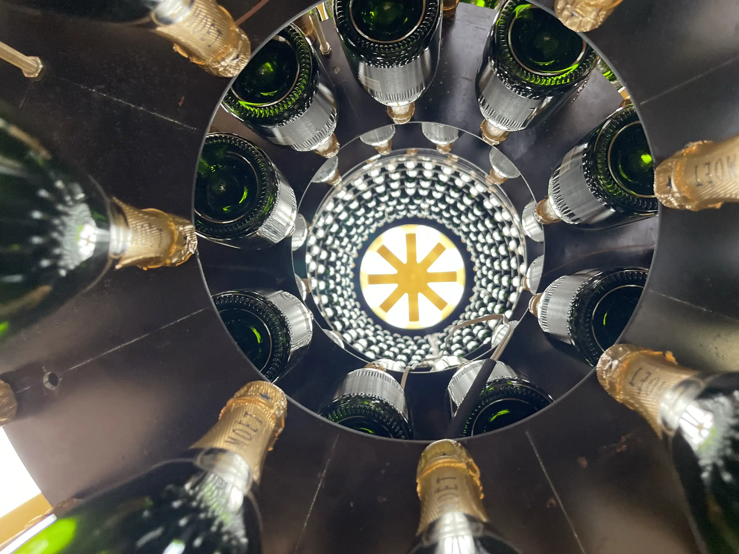 Ring of champagne bottles seen from below
