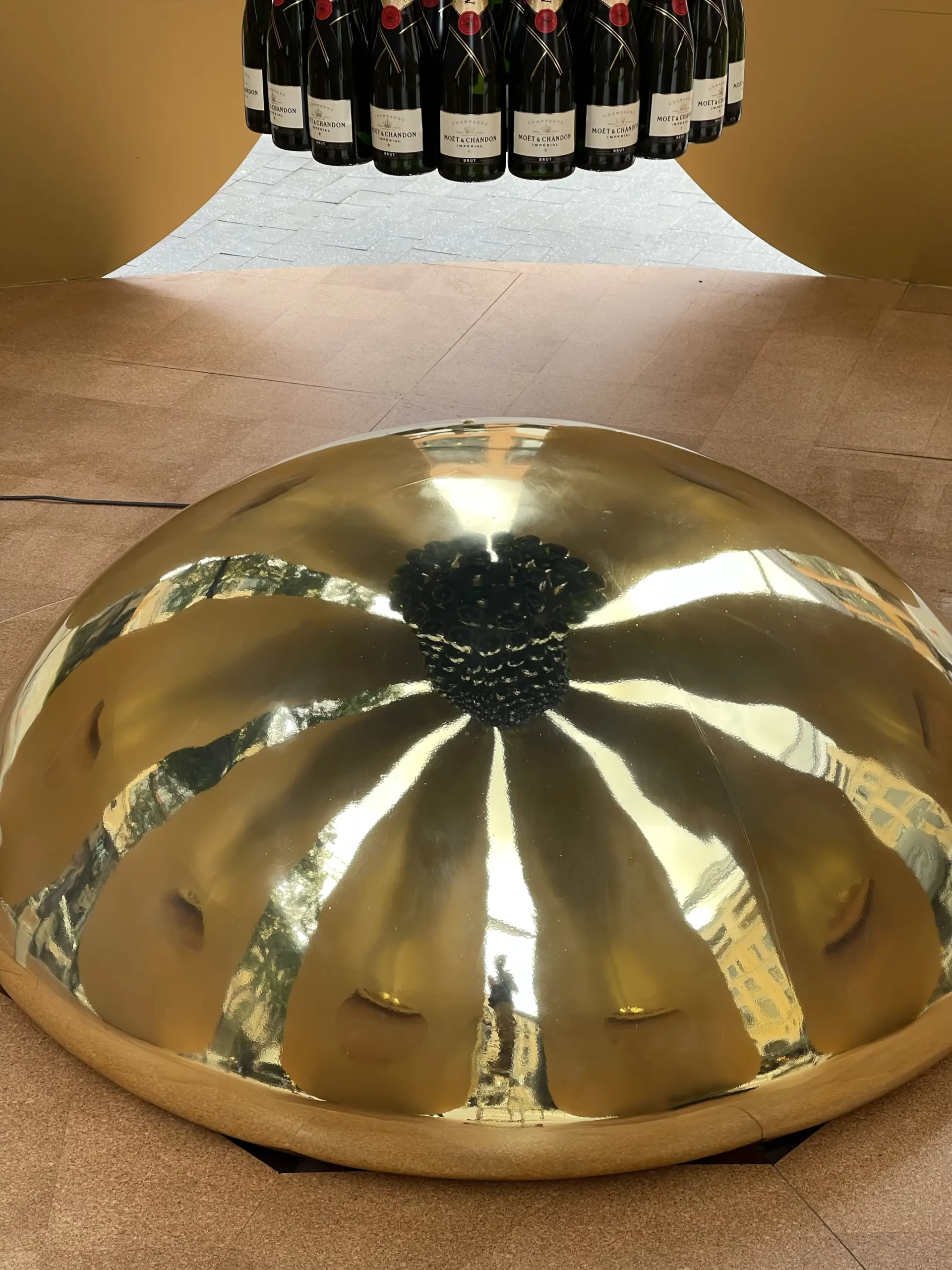 Polished gold dome at the base of the bottle tower